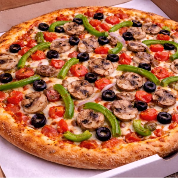 A whole pizza with mushrooms, green peppers, black olives, and diced tomatoes in a box.